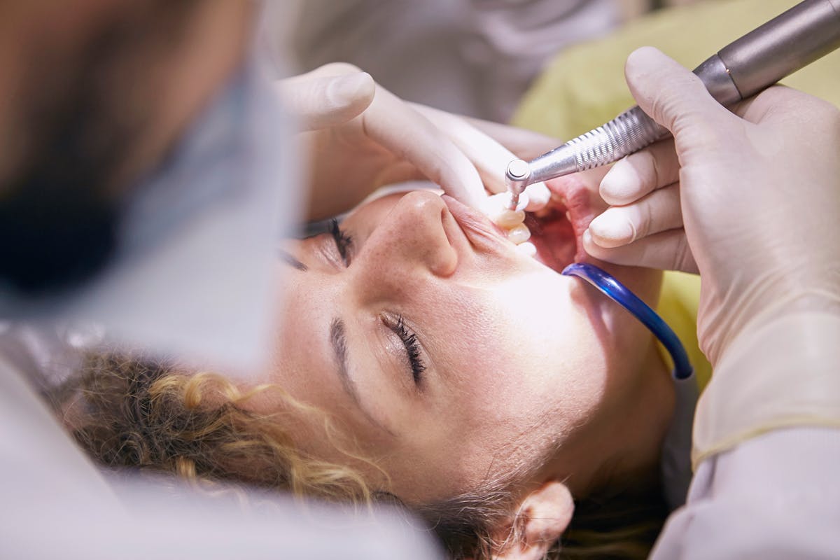 Dental hygienist cleaning teeth during a preventive visit